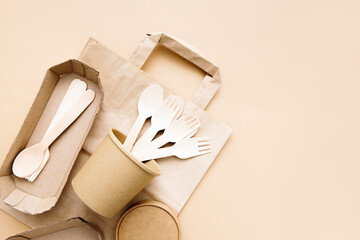 Zero waste, environmentally friendly, disposable, cardboard, paper utensils, spoons, forks on a beige background. View from the top. Eco craft paper tableware.