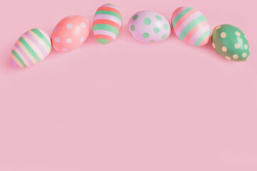 Fototapeta na wymiar Easter multi-colored eggs on a pink background lie in a row. High quality photo