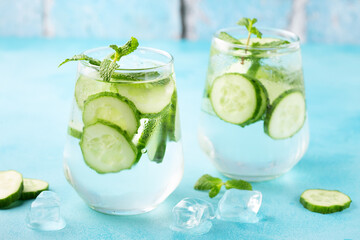 Fresh infused cucumber water on a light blue background