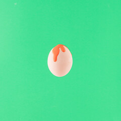 Creative arrangement made of egg painted red on a green background. Minimal Easter concept. Coloring eggs inspiration.