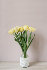 Bouquet of yellow tulips in a vase. Spring flowers. Bouquet in a vase. Cozy still life. Copy space. A festive greeting.