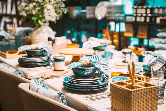 View of assortment of decor for interior shop in store of shopping center. Home accessories and household products for dining room in store of shopping centre. View of dinnerware, plate, bowl on table
