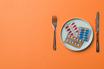 Many different weight loss pills and supplements as food on round plate. Pills served as a healthy meal. Drugs, pharmacy, medicine or medical healthycare concept