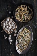 Pasta with mushrooms in a pan. Photo of food on a dark background