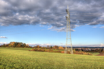 Pylon in the morning sun on the hill above the city. In large parts of Germany, electricity is...