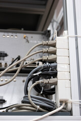 Full power outlet extension cord. Plugged in sockets, maximum capacity, overload danger. Set in industrial building, no people, shallow depth of field