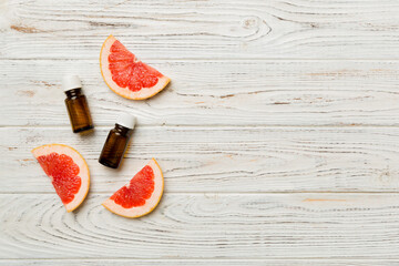 Bottles with Grapefruit fruit essential oil on wooden background. alternative medicine top view with copy space