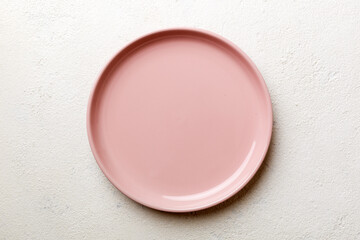 Top view of empty pink plate on cement background. Empty space for your design