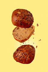 bread with sunflower seeds flying on a yellow background