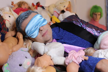 Eccentric man sleeping with mask , lots of dolls and stuffed animals