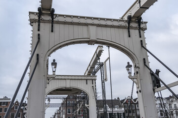 One of most beautiful bridges of Amsterdam - Magere Brug ("Skinny Bridge", 1871), bridge over river Amstel, popular historic site, narrow bridge for pedestrians & cyclists. Amsterdam, the Netherlands.