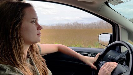 Fototapeta na wymiar Young woman driving a car - close up shot - travel photography