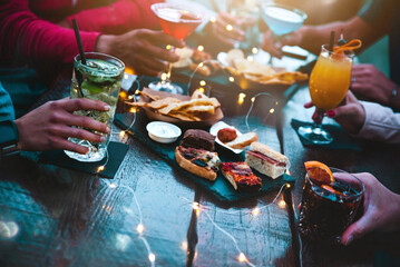 People hands holding cocktail glasses in bar table - Group of people eating appetizers enjoying happy hour time in pub restaurant - Beverage lifestyle concept - obrazy, fototapety, plakaty