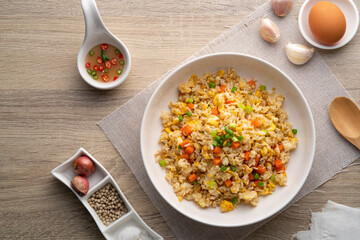 Thai Fried rice with egg and sliced carrot in white plate.Easy cooking food.Top view