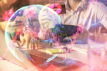 Double exposure of man and woman on-line shopping holding a credit card and business theme hologram drawing. E-commerce pay on-line concept.