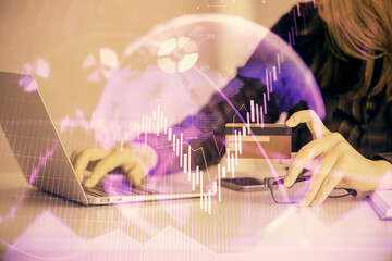 Double exposure of woman on-line shopping holding a credit card and financial graph drawing. Stock market E-commerce concept.