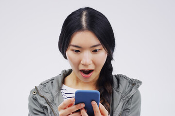 I cant believe my network provider is offering this. Shot of a young woman looking surprised while reading something on her cellphone.