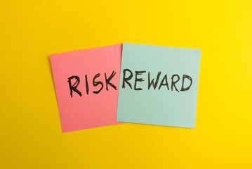 Words risk and reward handwritten on colorful sticky notes