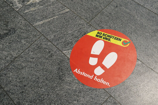 Derendingen, Switzerland, 03.01.2022: Sticker with Corona-Measures of Social Distancing on the floor when shopping.