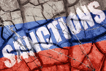 Cracked wasteland in the colors of the Russian flag behind barbed wire with word sanctions over it