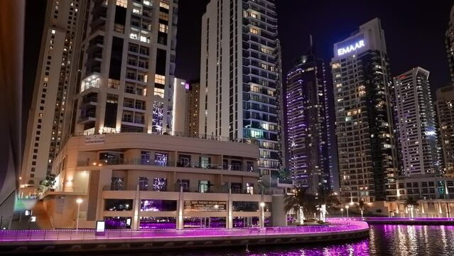 Time Lapse, Timelapse, Time-lapse. Night trip of Dubai Marina is a district in Dubai, United Arab Emirates. Dubai Marina Port, UAE, United Arab Emirates. Tourist boat, sightseeing boat sailing on