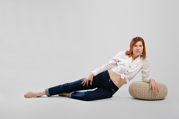 Barefoot middle age woman leaning on padded stool