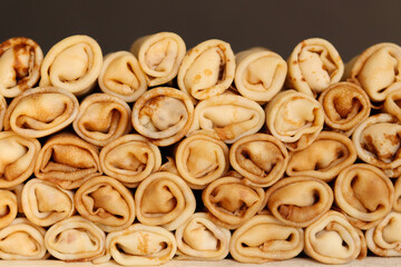 Stack of crepes rolls twisted with meat. Traditional Ukrainian russian thin pancakes as background. Tasty morning breakfast or lunch. Homemade food for maslenitsa. Banner. Close up view.