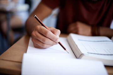 Developing good study habits. Closeup shot of a young student writing on a note pad. - obrazy, fototapety, plakaty