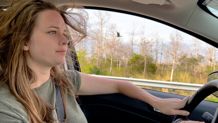 Fototapeta premium Young woman driving a car - close up shot - travel photography