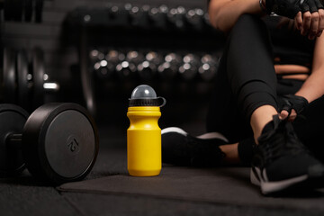 Fototapeta na wymiar Woman exercise workout in gym fitness breaking relax after training sport with dumbbell and protein shake bottle healthy lifestyle bodybuilding, Athlete muscles lifestyle.