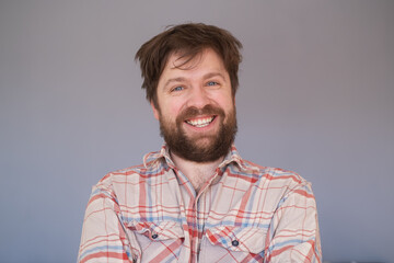 Obraz premium Happy young bearded guy looking at camera, brightfully smiling with teeth