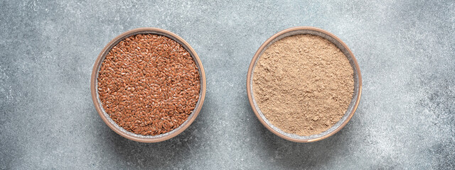 Flax flour. Flaxseed flour in a bowl on a gray concrete grunge background. Top view, flat lay....