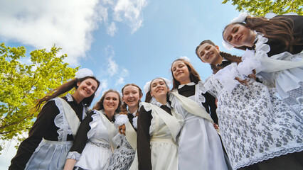 Smiling female graduates pose on the last day of school life.