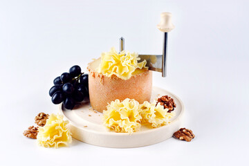 Traditional tete de moine aged mountain cheese of the Alps served with grapes and walnuts on a...