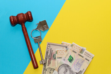 The key to the apartment with a keychain in the shape of a house on a blue yellow background, the...
