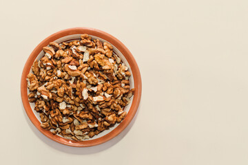 Plate with walnut grains on a beige background.