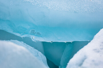 Water drops on winter blue ice