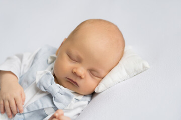newborn baby boy in a suit sleeping on a  white background. Happy pregnancy and childbirth. Health concept.