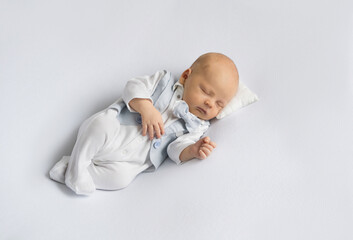 newborn baby boy in a suit sleeping on a  white background. Happy pregnancy and childbirth. Children's theme. Top view