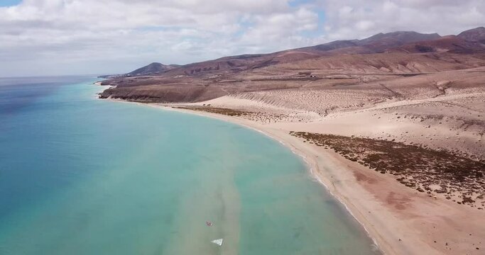 Amazing tropical beach anc blue transparent sea ocean water. Aerial view of coastline and amazing seascape landscape with horizon and sky and mountains in background. Summer travel