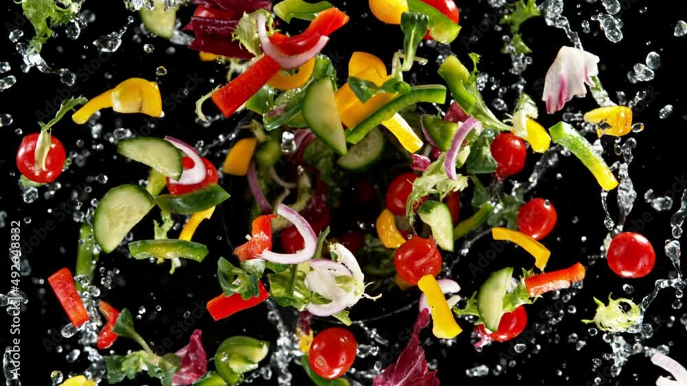 Poster super slow motion of rotating fresh lettuce flying up in the air. splashing water. isolated on black