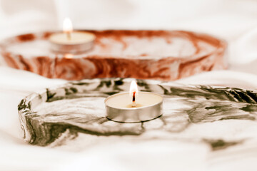 Gypsum marble decorative stand with candles on the background of silk stand.