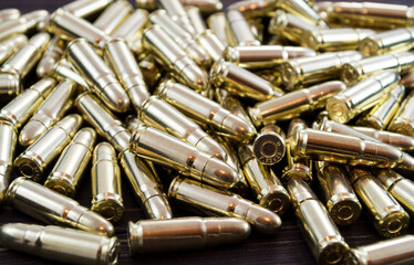 Golden pistol bullets on a wooden background