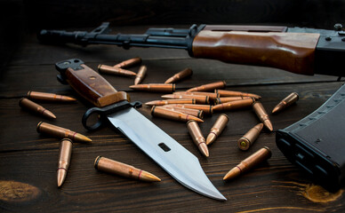 Assault rifle AK47, bayonet and bullets isolated on wooden background