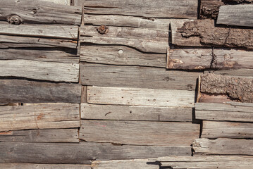Wooden bark wall made of assembled tree logs
