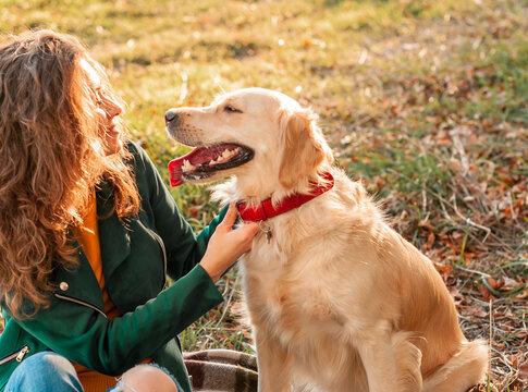 Happy woman rest with her dog golden retriever. Female girl enjoying outdoor with her pet. woman is training outside during spring
