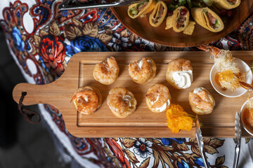 A treat for a buffet or a house party. Profiteroles made from custard dough with cream mousse of shrimp.