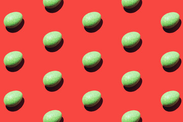 Pattern made of green eggs on red background. Minimal Easter or food concept.