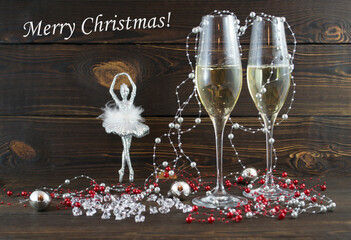 Cozy magical Christmas background for writing with Glasses of champagne and festive silver decoration deer fairy ornament on wooden vintage background