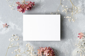Invitation or greeting card mockup with white gypsophila and hydrangea flowers. Blank card mockup.